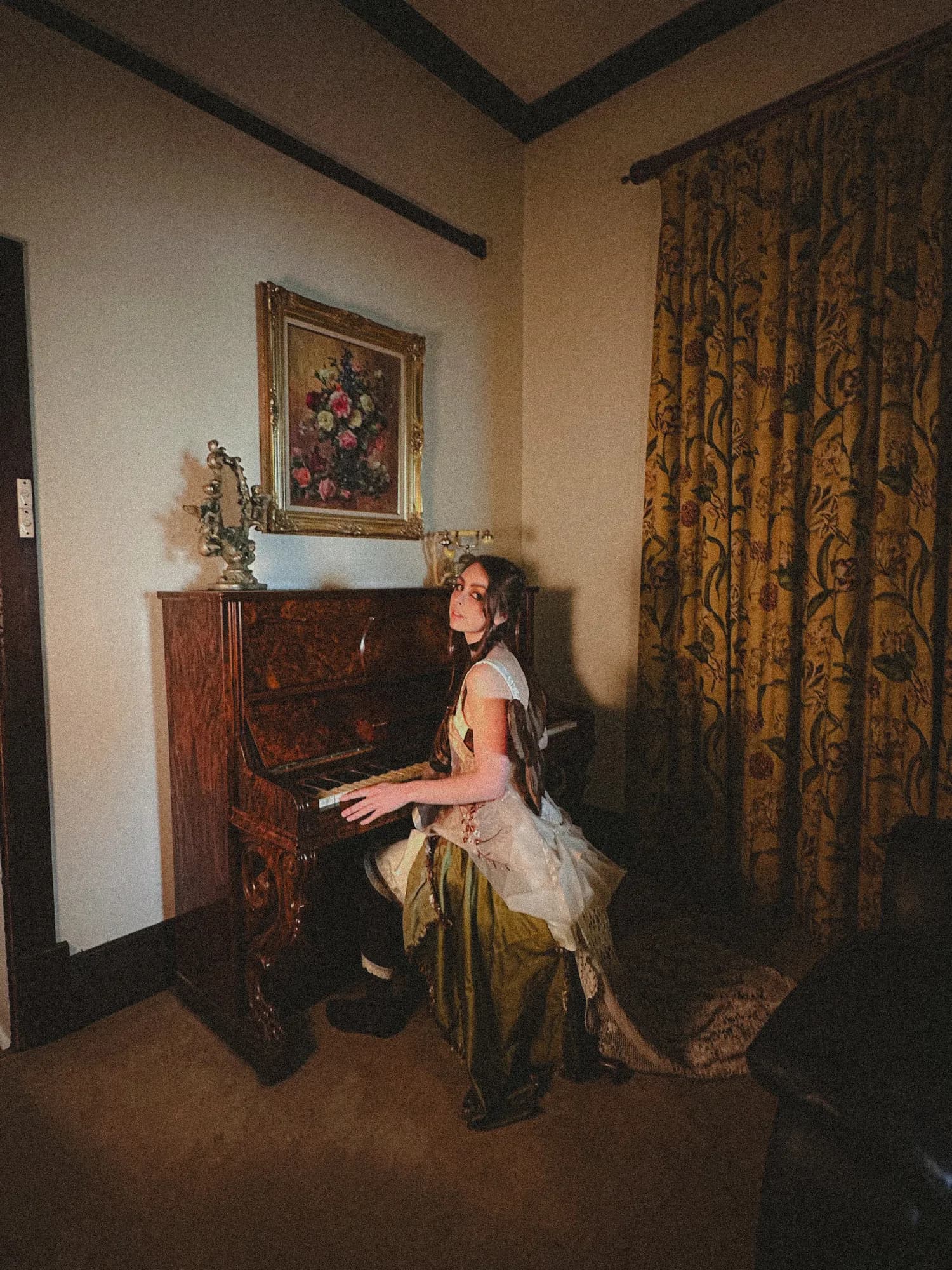 Solly Fern playing an upright piano in a vintage parlour room