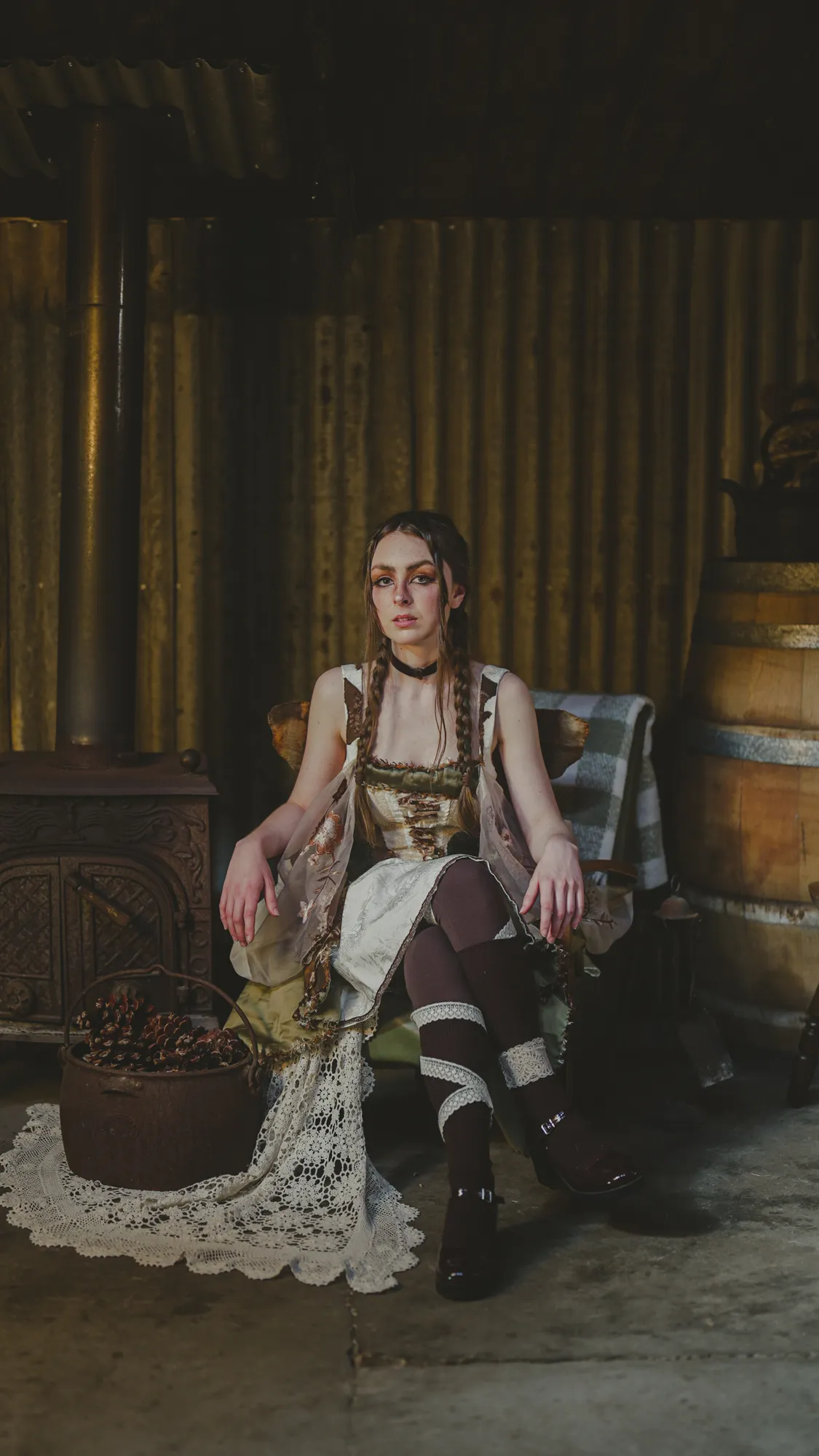 Solly Fern seated in a corrugated iron shed beside a wood stove and a lace cloth